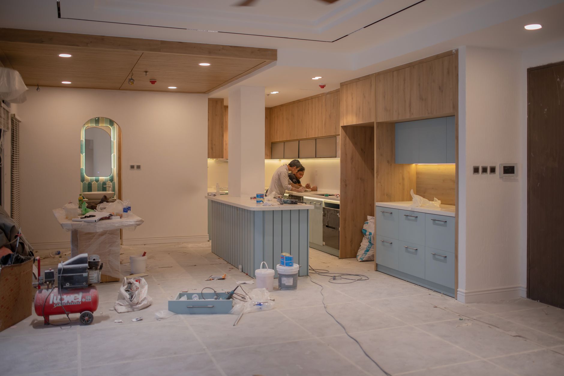 A modern kitchen undergoing renovation, featuring a worker, tools in Riverside, CA