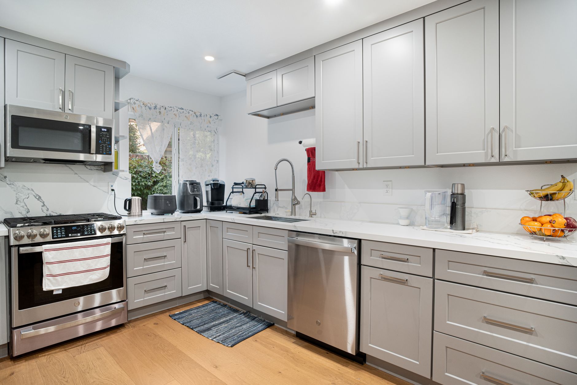 Sleek modern kitchen featuring stainless steel appliances and light grey cabinetry in Riverside, CA